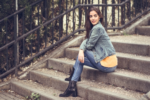 Woman with nice hair wearing casual clothes in urban steps.