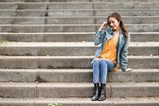 都市の階段でカジュアルな服を着ていい髪の女性。