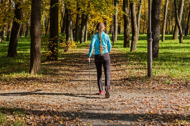 woman with nordic walking poles on park