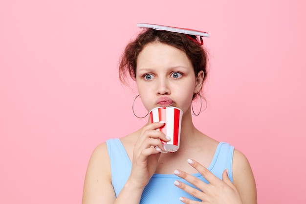 Woman with notepad and glass in hands drink pink background unaltered