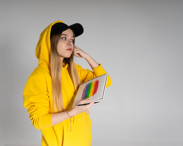 Woman with a notepad on which a rainbow lgbtq, the girl straightens her hair