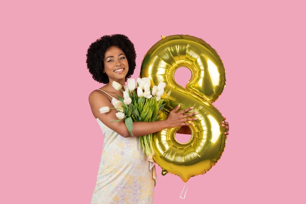Woman with number balloon and tulips smiling