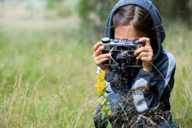 Donna con una vecchia macchina fotografica d'epoca nel parco