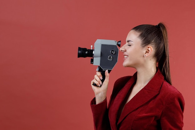 Woman with old vitage movie camera studio shot isolated