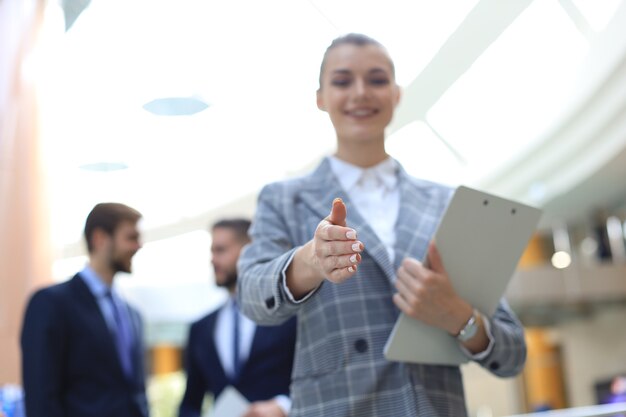 Woman with an open hand ready for handshake in office.