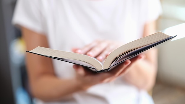 Woman with open paper book reading bestseller concept in bookstore