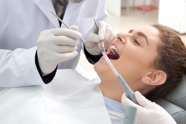 Woman with opened mouth lying in dentist chair.