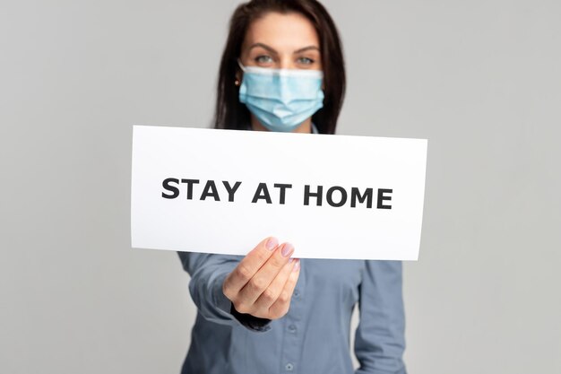 Woman with paper banner stay at home during quarantine