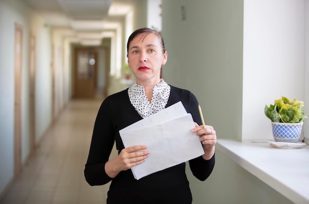 사무실에서 서류를 들고 있는 여성 복도에 있는 동료
