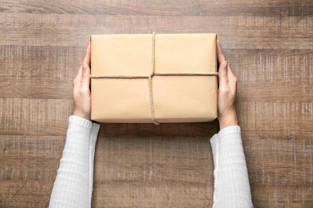 Woman with parcel box on wooden background