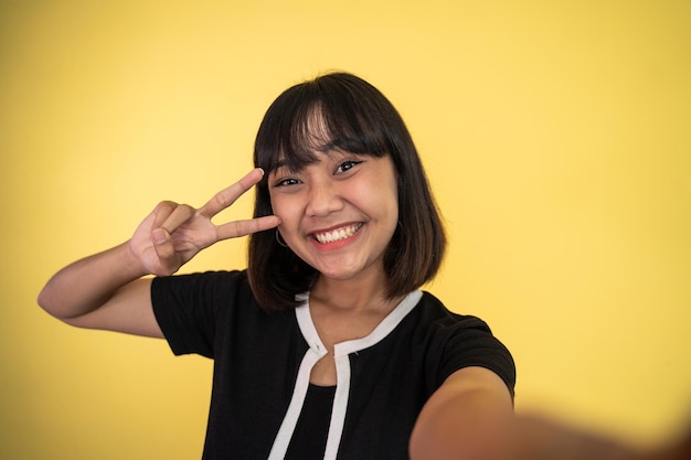 Woman with peaceful hand gesture on isolated background