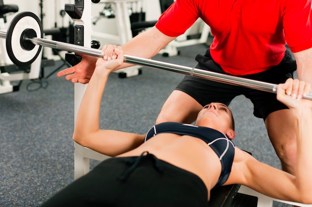 Donna con personal trainer in palestra