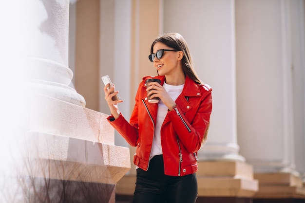 電話とコーヒーを持つ女性