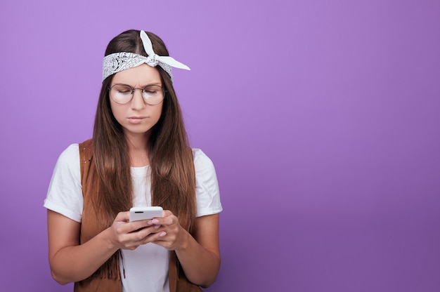 Woman with a phone in her hands on a flat background.