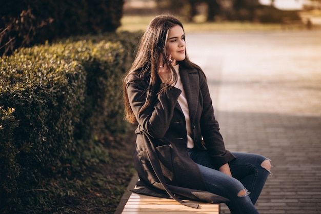 woman with phone sitting on a bench