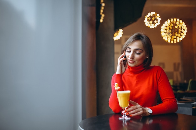 カフェに座っている電話で女性