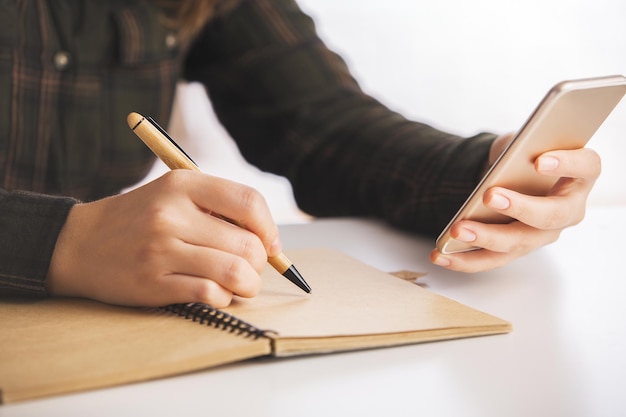 Woman with phone writing