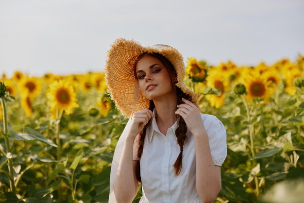 Woman with pigtails looking in the sunflower field\
countryside