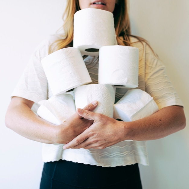 Woman with a pile of toilet tissue rolls