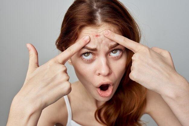 Woman with a pimple on the face cosmetology studio