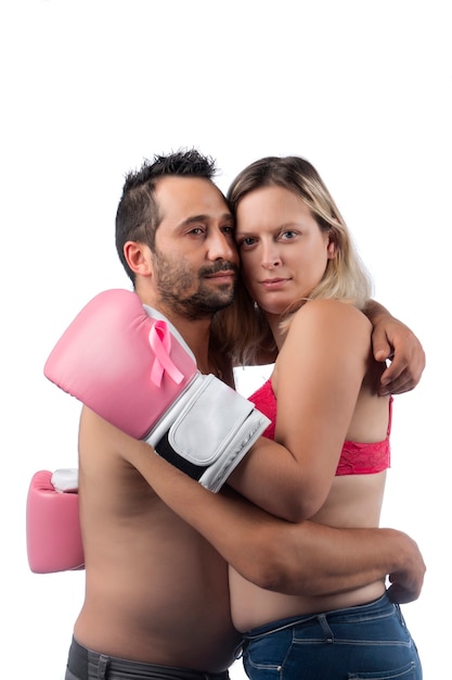 Woman with pink boxing gloves hugging husband for support symbolizing breast cancer fighting awareness