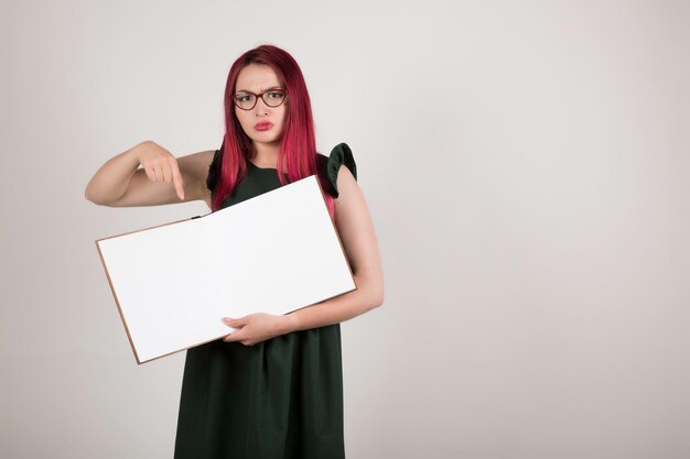 Woman with pink hair holding book