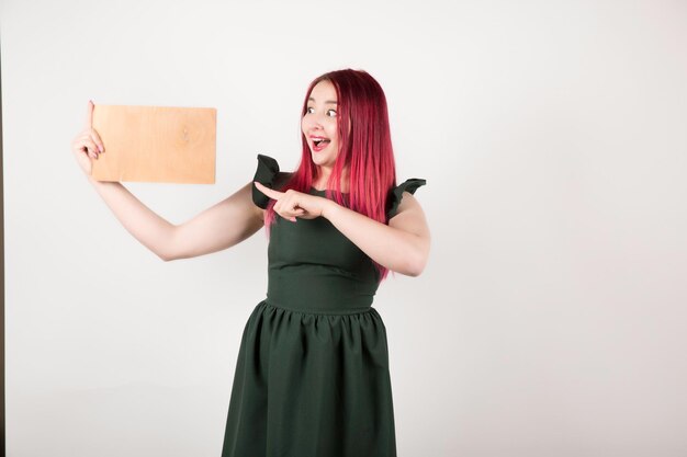 Woman with pink hair on white holding book