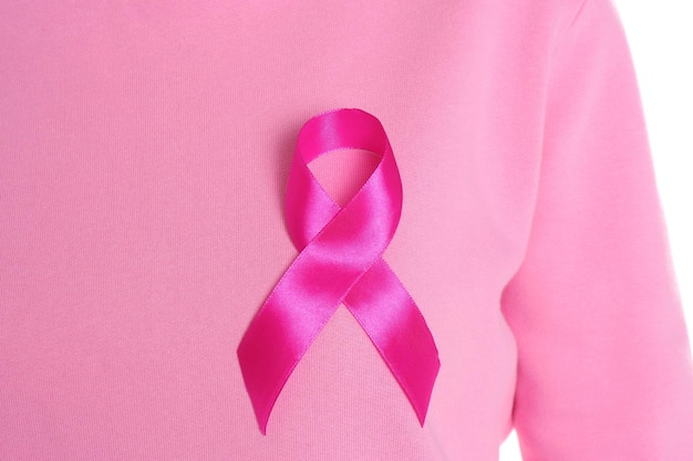 白い背景のクローズ アップにピンクのリボンを持つ女性乳がんの意識