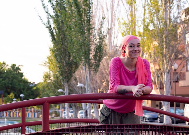 Woman with a pink scarf on her head in the park