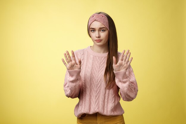 黄色の上にピンクのセーターを着た女性