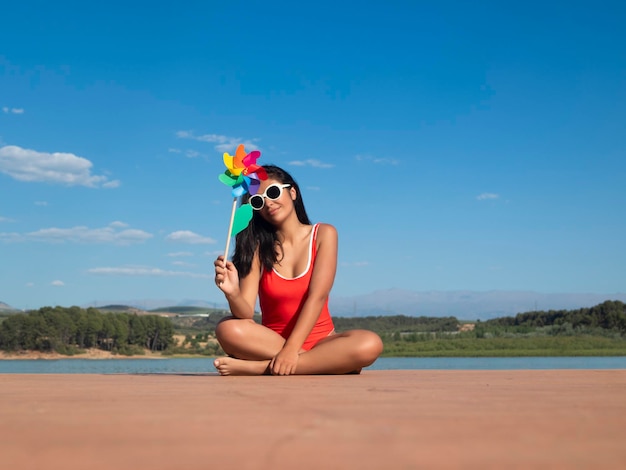 Woman with pinwheel on pier in summer