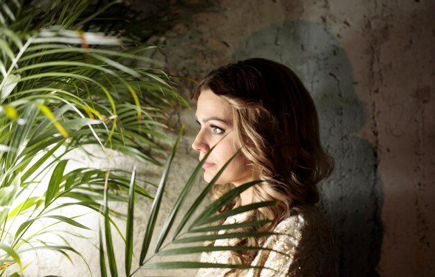 Photo woman with plant against wall