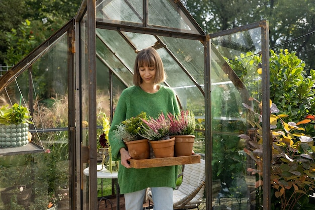 裏庭で植物を持つ女性