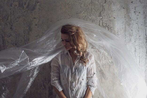 Photo woman with plastic against wall