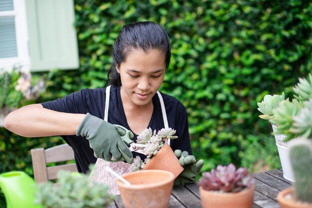 庭に鉢の植物を持った女性