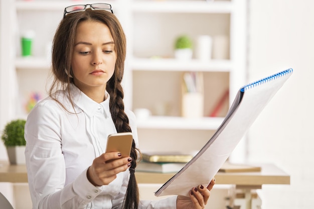 Woman with project using smartphone