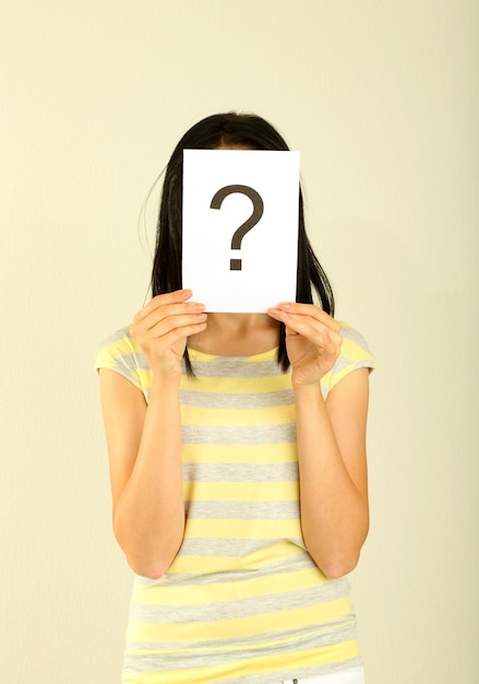 Woman with question marks on grey background