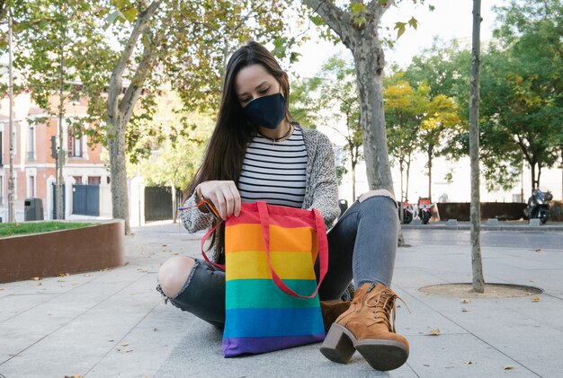 Woman with rainbow bag on street