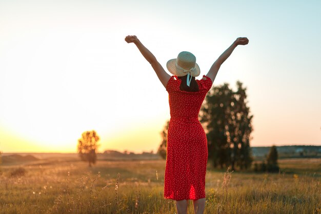 Woman with raised hands enjoying sun in the field