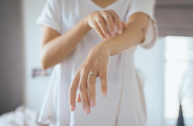 Woman with rash or papule and scratchon her arm from allergiesHealth allergy skin care problem