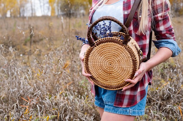 Photo woman with rattan woven round shoulder handbag outside fall season