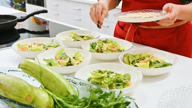 Woman with red apron cooking in a white kitchen