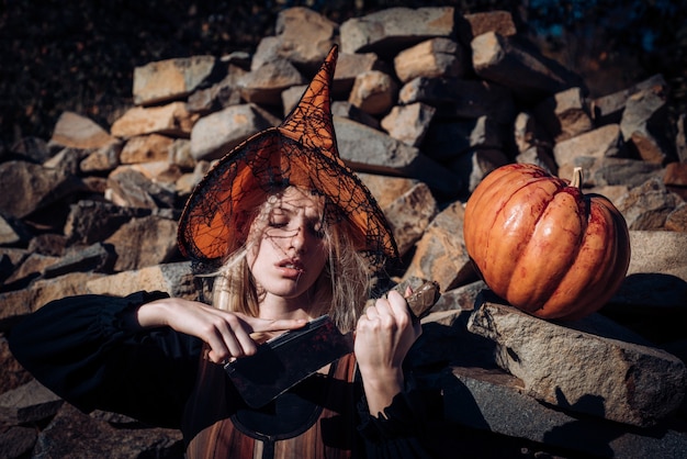 Donna dal sangue rosso e dai capelli biondi. ragazza sanguinante spaventosa in cappello arancione dello stregone con la zucca. disegno artistico della festa di halloween. insieme di elementi divertenti di halloween. concetto di impavidità.