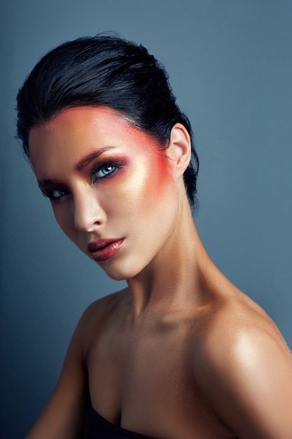 woman with red bright makeup on her face and eyes