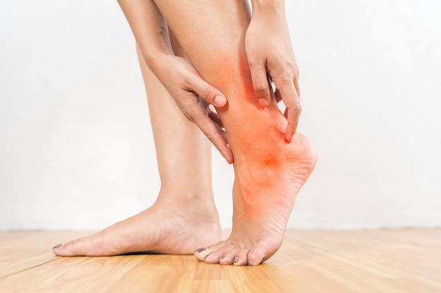 A woman with a red foot is holding her leg