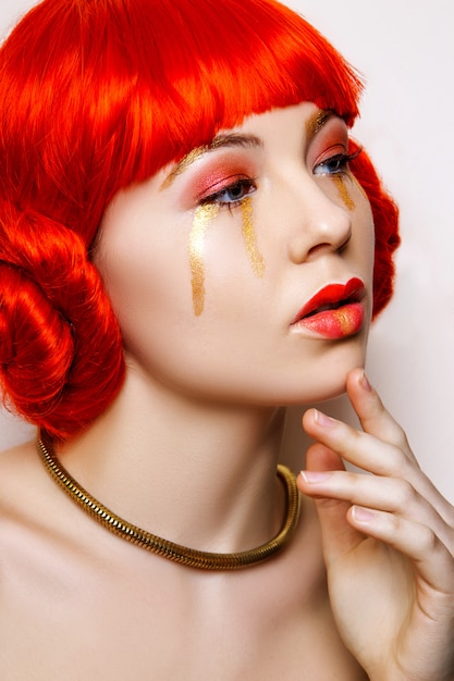 Woman with red and gold make up and red hair