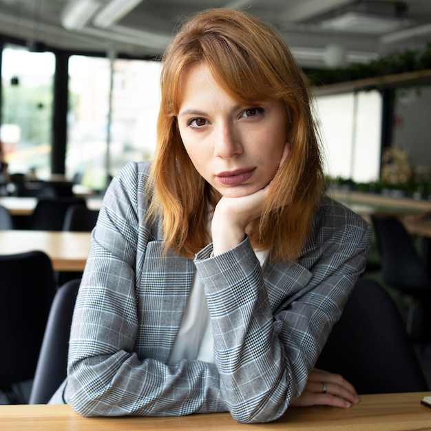 Woman with red hair in a grey jacket