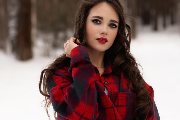 Woman with red lips in winter forest