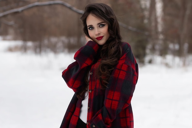 Woman with red lips in winter forest