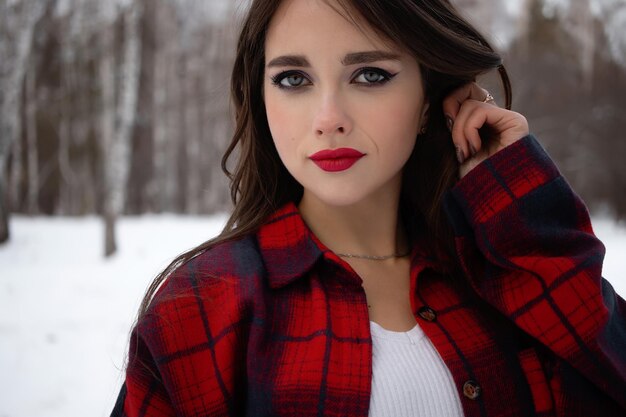 Woman with red lips in winter forest